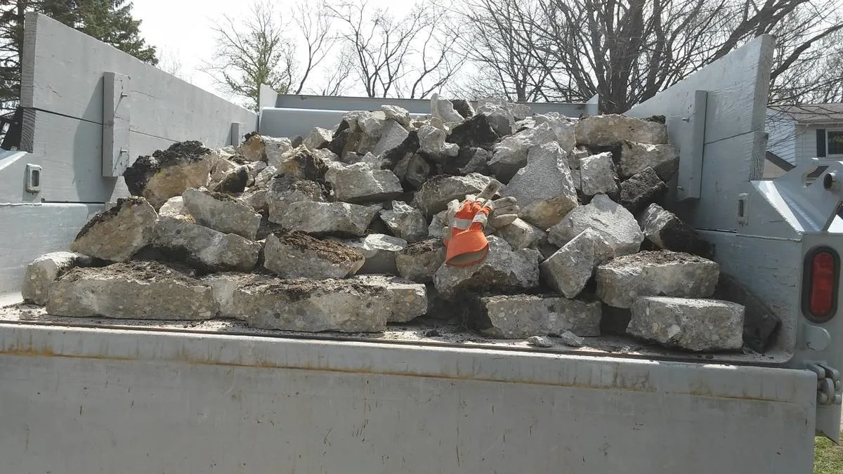 Broken concrete slab pieces loaded in a dump trailer for hauling